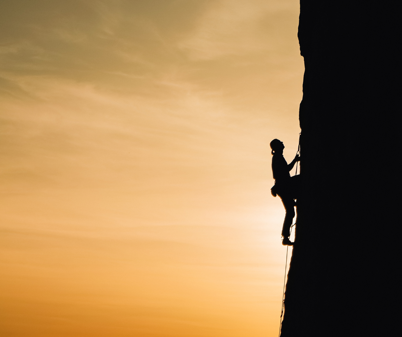 Person scaling a rock wall